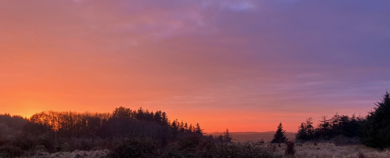 Aftenhimmel over &aring;bent landskab i Nordvestjylland